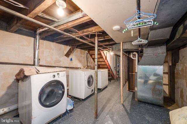 clothes washing area with separate washer and dryer and heating unit