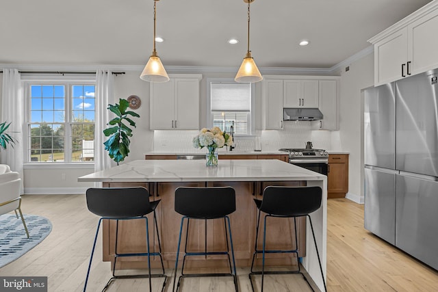 kitchen featuring white cabinetry, stainless steel appliances, and light stone counters