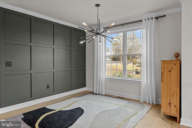 dining space featuring a chandelier, crown molding, light hardwood / wood-style flooring, and a healthy amount of sunlight