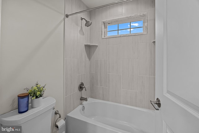 bathroom featuring tiled shower / bath combo and toilet