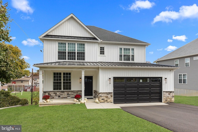 view of front of house with a front yard, a garage, and a porch