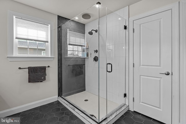 bathroom with an enclosed shower and tile patterned flooring