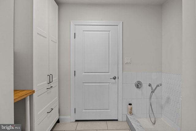 bathroom featuring tile patterned floors and a tile shower