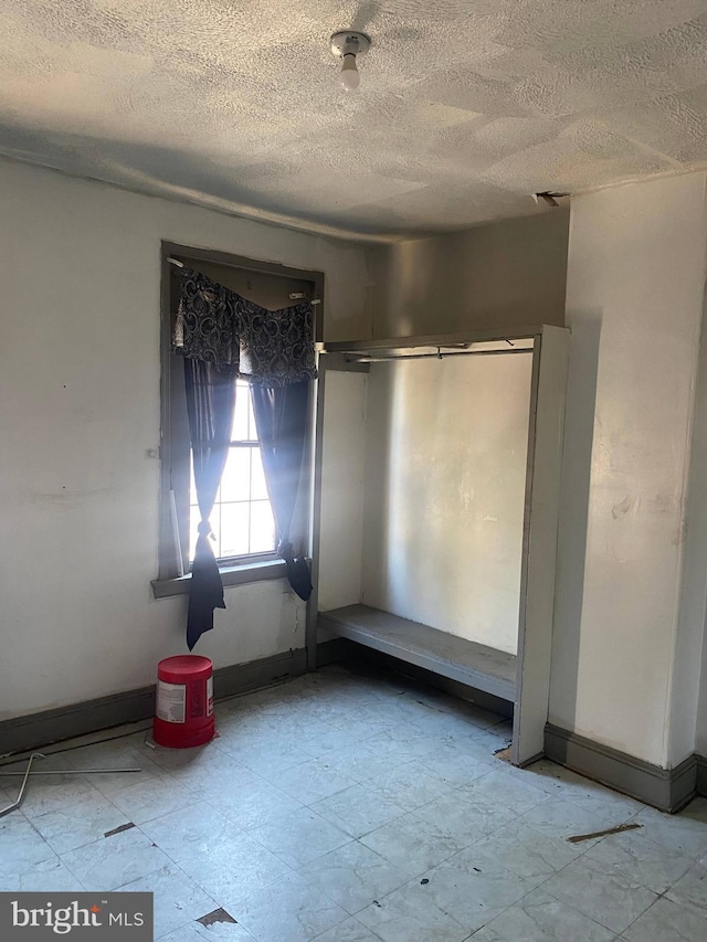 unfurnished room with a textured ceiling