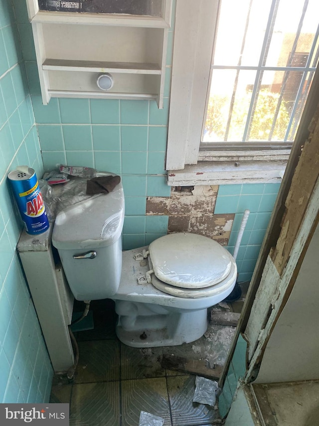 bathroom featuring tile walls and toilet