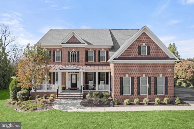 view of front of property with covered porch and a front lawn