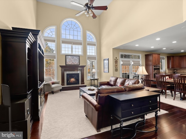 living room with a high ceiling, plenty of natural light, and ceiling fan