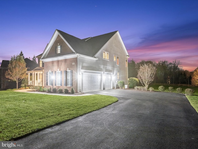 view of front of property with a garage and a yard