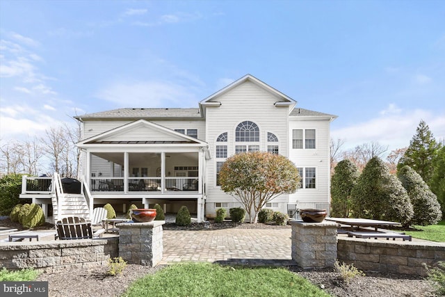 back of property with a patio and a sunroom