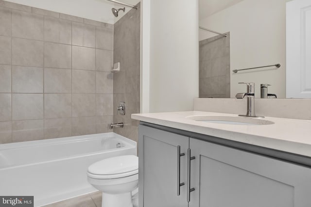 full bathroom featuring tiled shower / bath, vanity, toilet, and tile patterned flooring