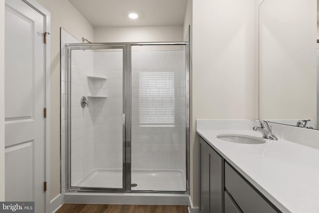 bathroom with vanity, a shower with door, and hardwood / wood-style floors