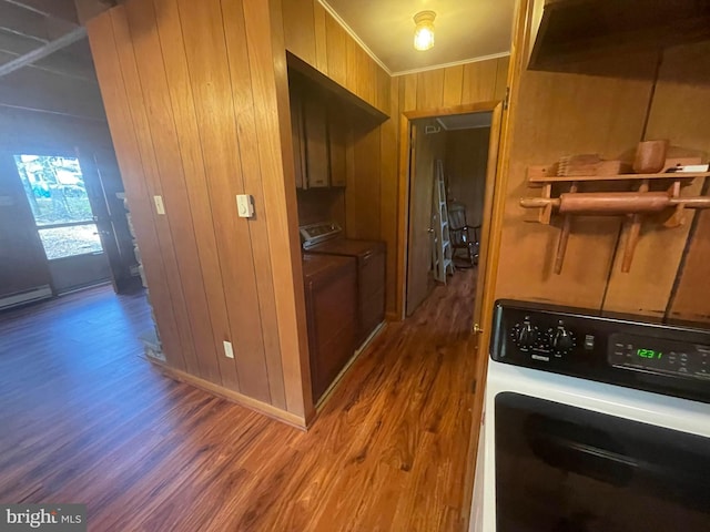 clothes washing area featuring wood walls, cabinets, independent washer and dryer, crown molding, and hardwood / wood-style floors