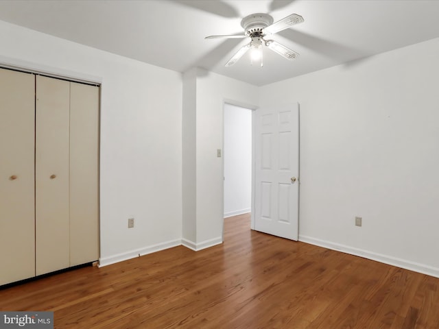 unfurnished bedroom featuring a closet, wood-type flooring, and ceiling fan