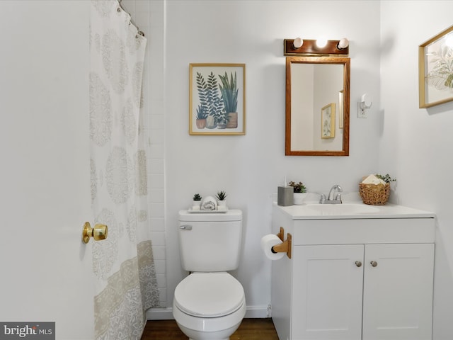 bathroom with vanity, toilet, hardwood / wood-style flooring, and walk in shower