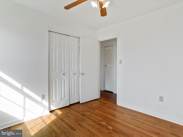 unfurnished bedroom featuring a closet, ceiling fan, and wood-type flooring