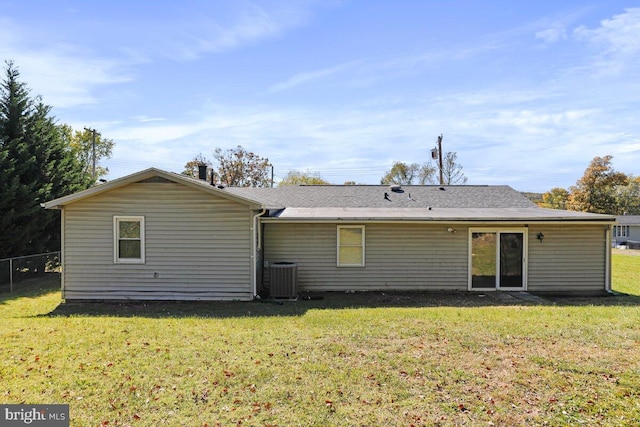 back of property with central air condition unit and a lawn