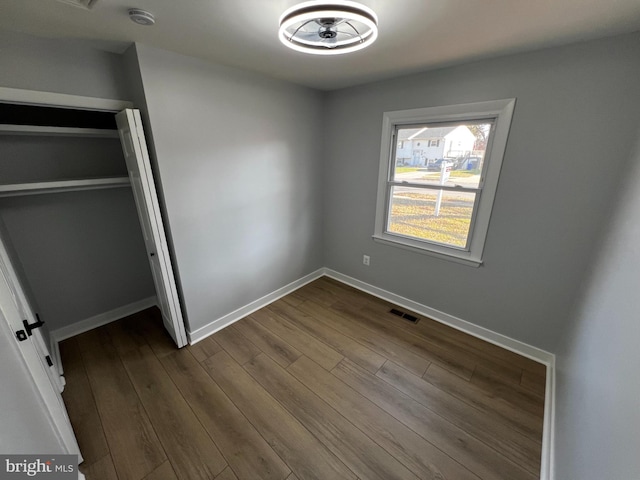 unfurnished bedroom with hardwood / wood-style floors and a closet