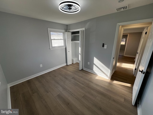 unfurnished bedroom with wood-type flooring and a closet