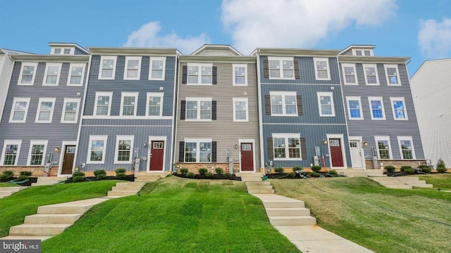 townhome / multi-family property featuring a front lawn