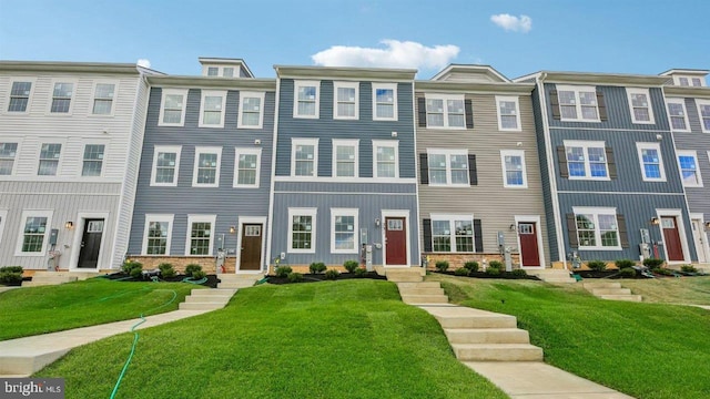 townhome / multi-family property featuring a front lawn