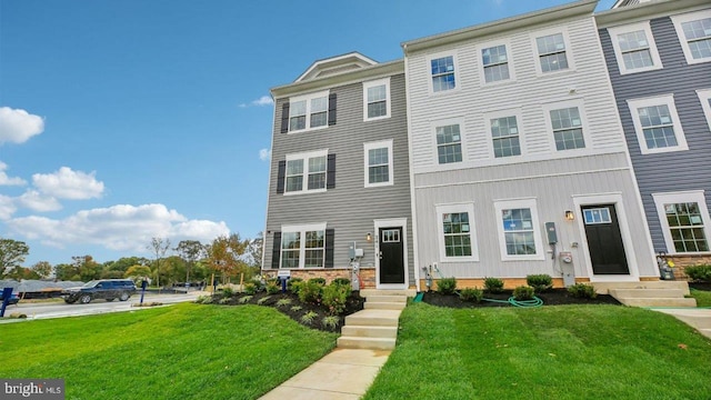 townhome / multi-family property featuring a front lawn