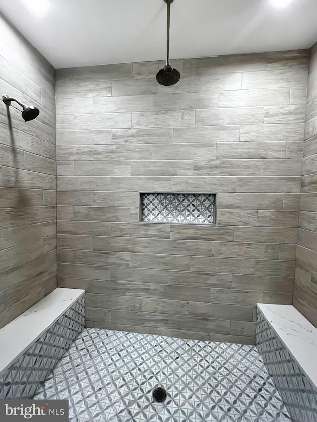 full bathroom featuring tile patterned floors and a tile shower