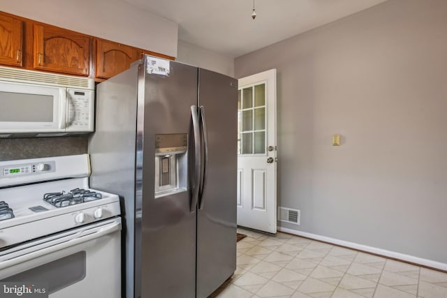 kitchen featuring light tile patterned floors and white appliances