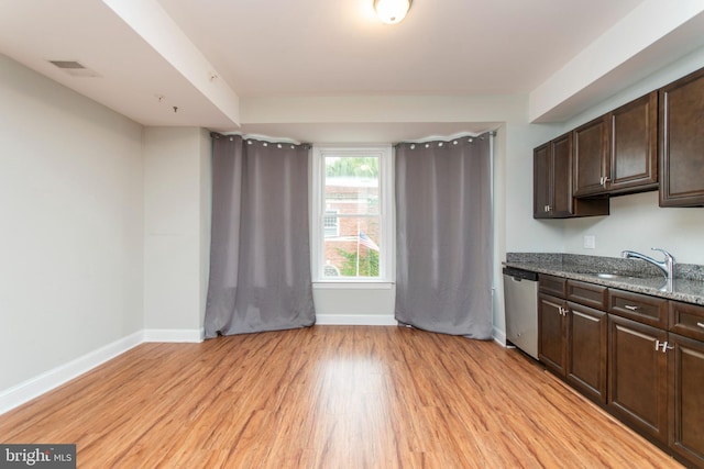 kitchen featuring stainless steel dishwasher, light wood-type flooring, dark brown cabinets, a sink, and baseboards