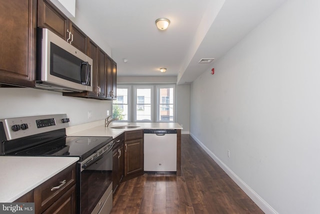 kitchen with stainless steel appliances, dark hardwood / wood-style floors, dark brown cabinetry, and sink