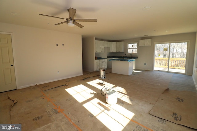 unfurnished living room featuring ceiling fan