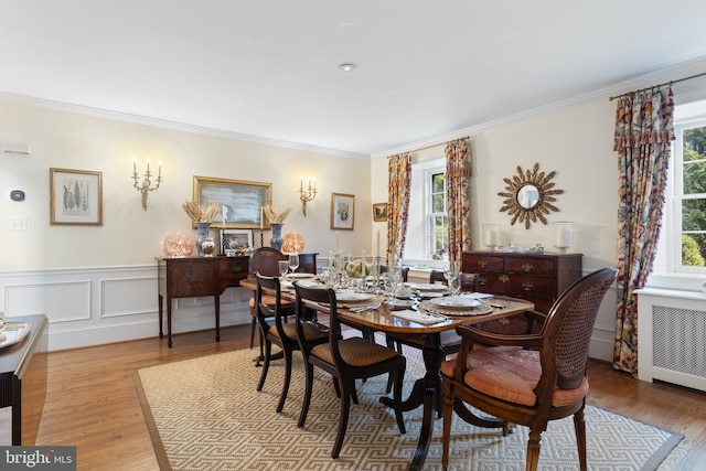 dining room featuring crown molding, wood finished floors, and radiator heating unit