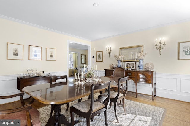 dining space featuring light hardwood / wood-style floors and ornamental molding