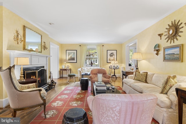 living room with a warm lit fireplace and wood finished floors