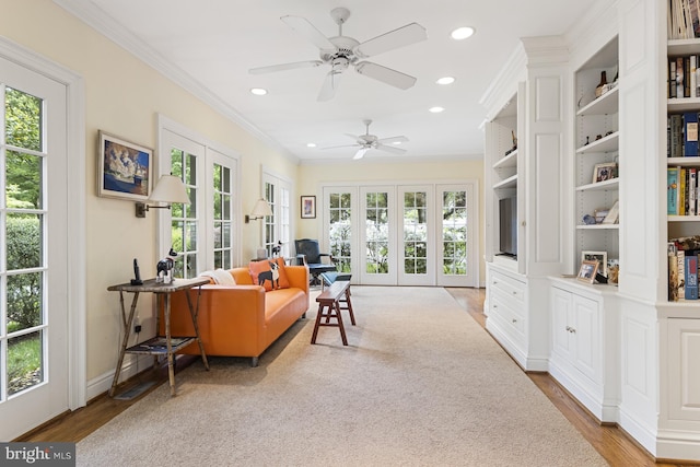 sitting room with french doors, ceiling fan, ornamental molding, and light hardwood / wood-style flooring