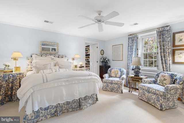 bedroom with a walk in closet, carpet, visible vents, and crown molding