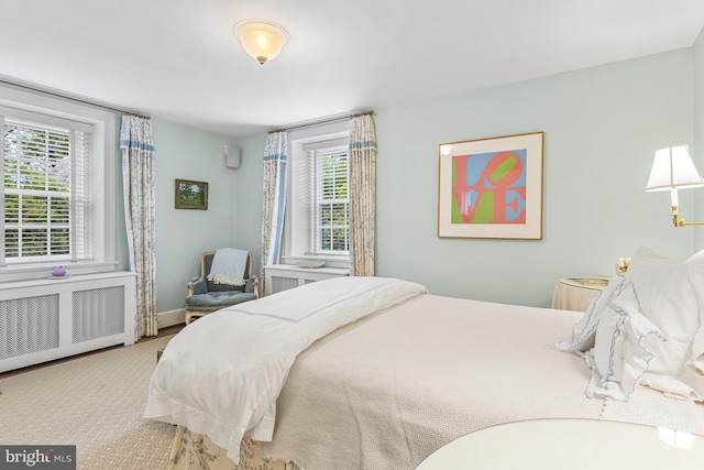 carpeted bedroom with multiple windows and radiator