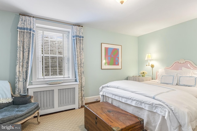 bedroom with radiator heating unit and light colored carpet