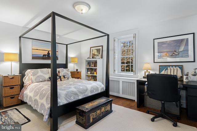 bedroom featuring wood finished floors and radiator