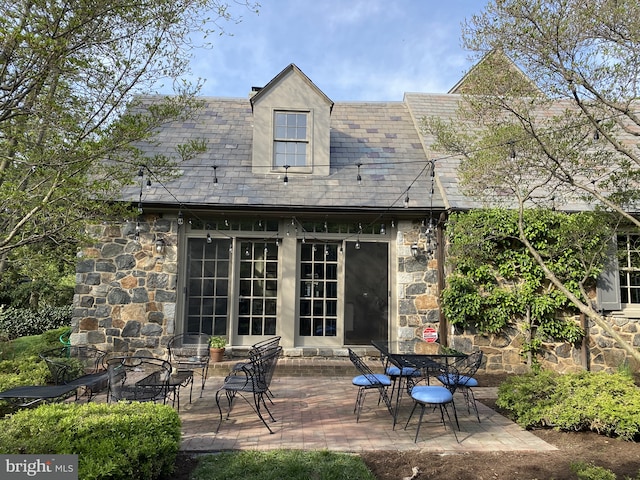 back of house with a patio area and stone siding