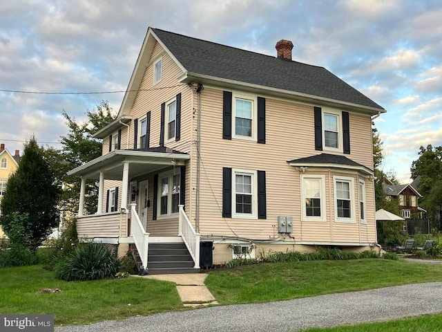 view of front of house with covered porch and a front yard