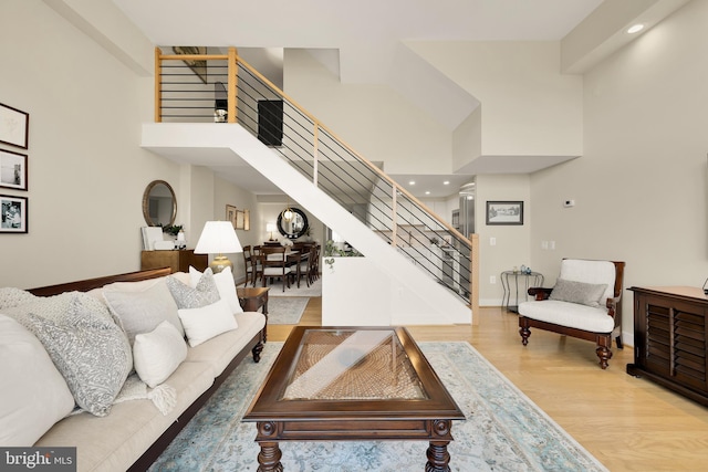 living room with wood-type flooring and a high ceiling