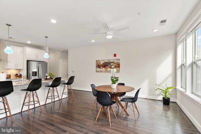 dining space featuring sink, ceiling fan, and dark hardwood / wood-style flooring