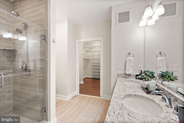 bathroom with vanity, a shower with shower door, and hardwood / wood-style floors