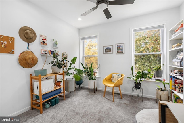 sitting room featuring ceiling fan, carpet, and a healthy amount of sunlight