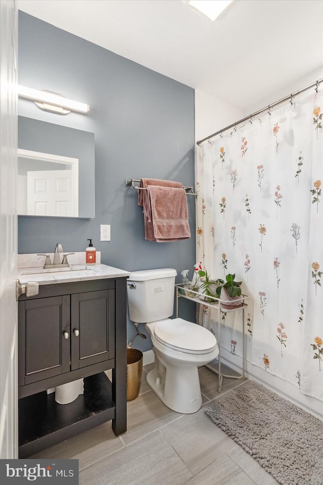 bathroom featuring curtained shower, vanity, and toilet