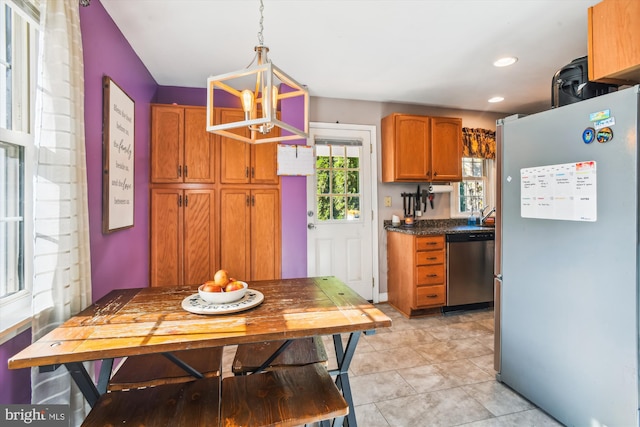 kitchen with appliances with stainless steel finishes, an inviting chandelier, hanging light fixtures, and light tile patterned floors