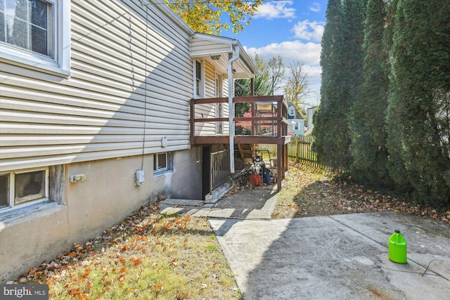 view of home's exterior with a patio and a wooden deck