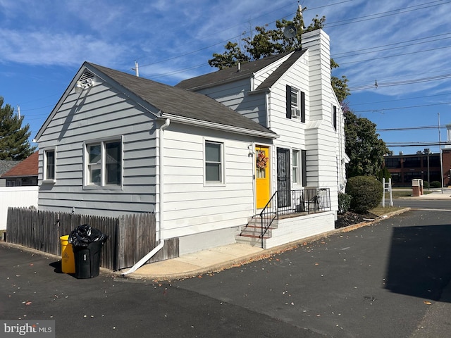 893 Parkway Ave, Ewing, NJ 08618 - view of front of property featuring a shingled roof, a chimney, and fence