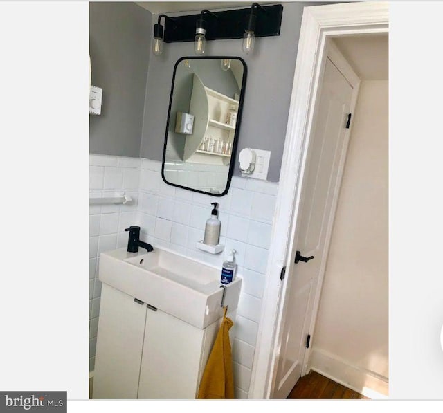 bathroom with tile walls, vanity, and hardwood / wood-style flooring