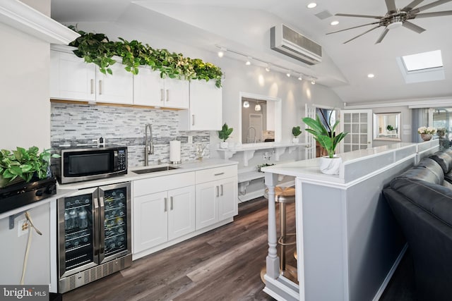 kitchen with lofted ceiling, white cabinets, an AC wall unit, sink, and wine cooler